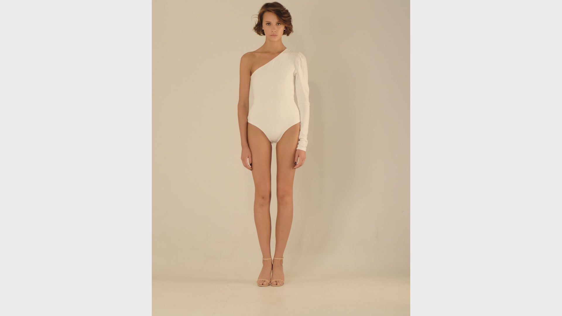 This bodysuit's model highlights the collarbone area and gracefully shows right shoulder and arm. The sleeve has wider body on the upper part which creates an elegant look.