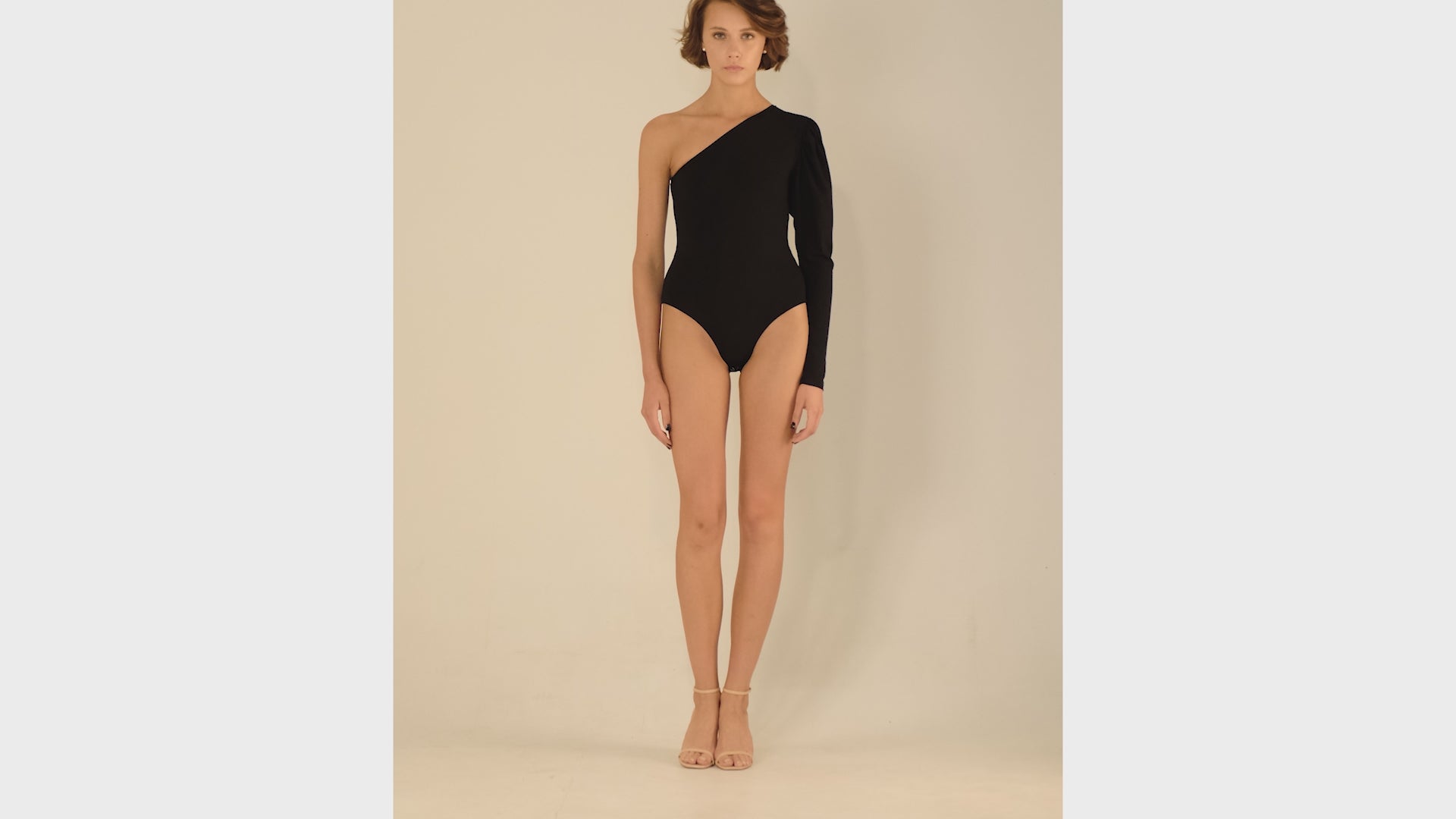 This bodysuit's model highlights the collarbone area and gracefully shows right shoulder and arm. The sleeve has wider body on the upper part which creates an elegant look.